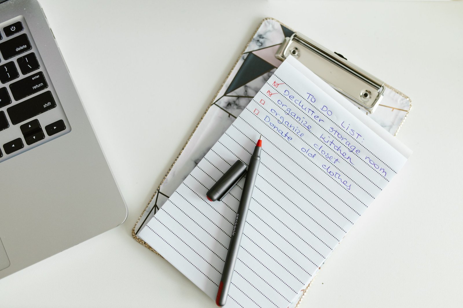 Liste de contrôle sur un porte-documents, à côté d'un ordinateur portable