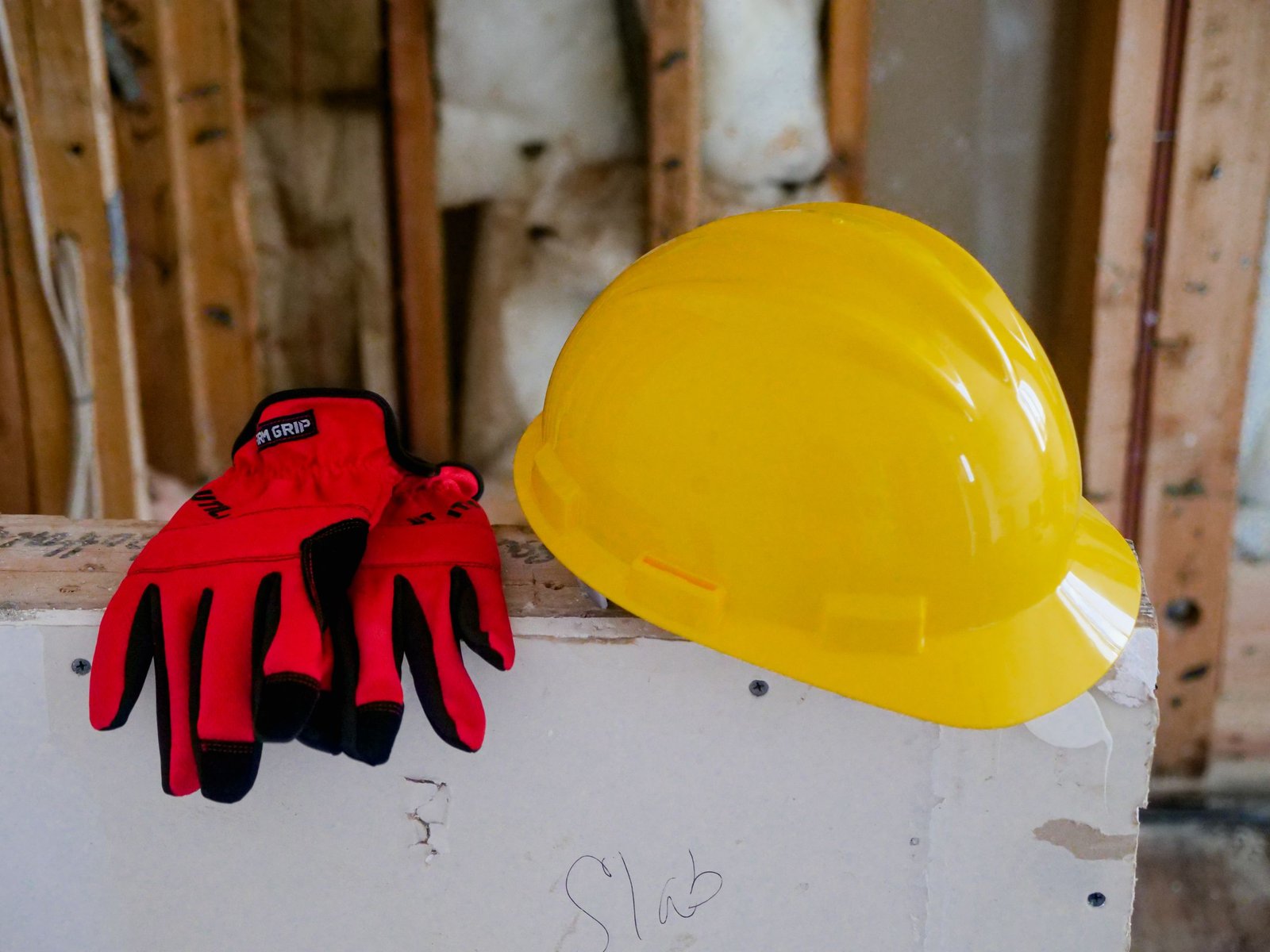 Casque de chantier jaune et gants de protection rouges