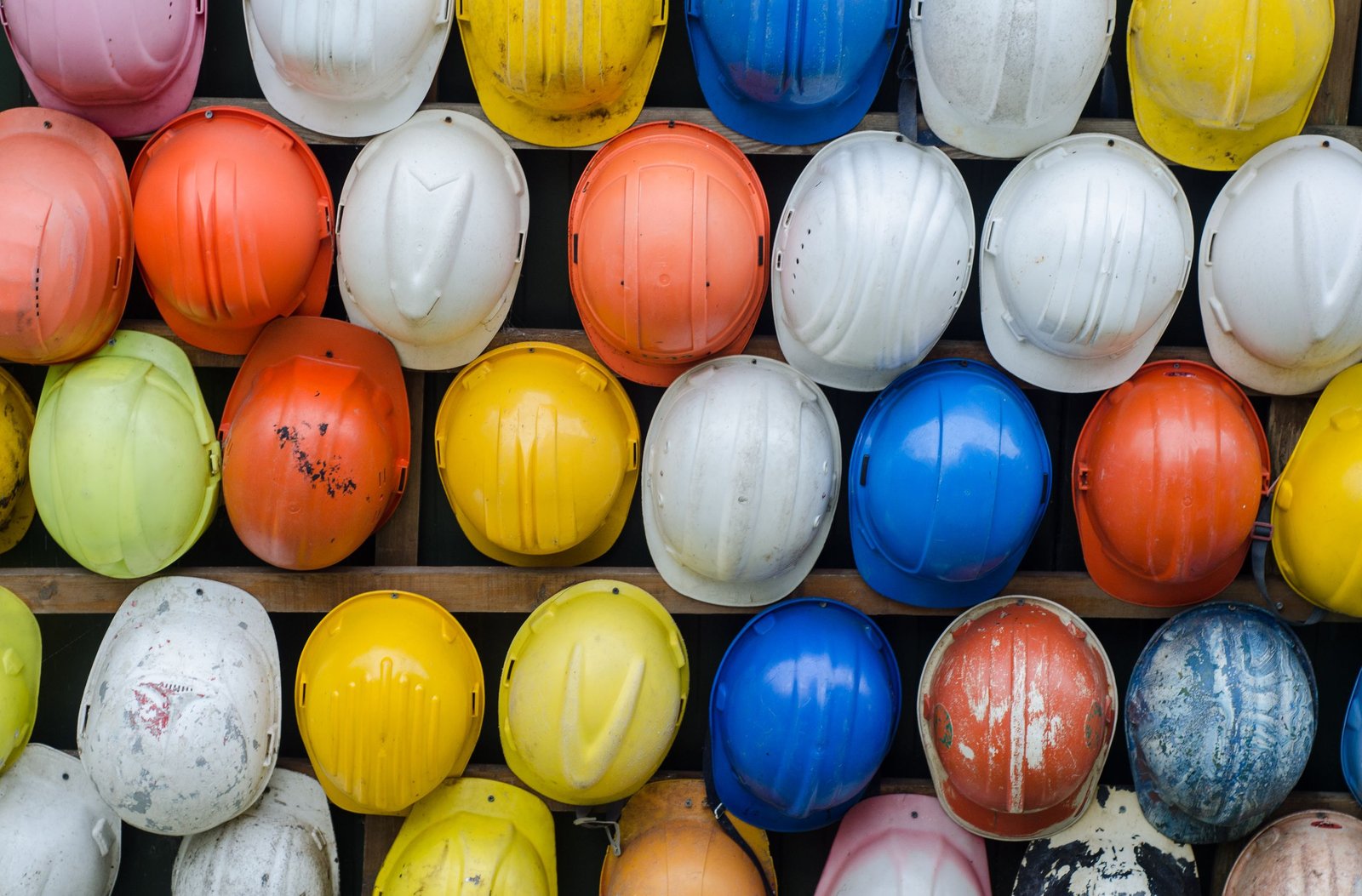 Casques de sécurité de chantier alignés sur un mur